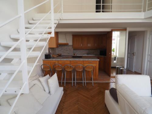 Il comprend un salon avec un escalier blanc et une cuisine. dans l'établissement Appartement T4 Duplex Centre Arcachon, Terrasse Sud, Proche Plage et Commerces, Parking Inclus - FR-1-474-3, à Arcachon