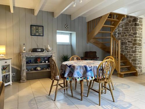 une salle à manger avec une table et des chaises et un escalier dans l'établissement Maison de Charme à Erdeven, Proche Plages et Sentiers, 3 Pièces, 4 Pers, Cour Privée - FR-1-397-38, à Erdeven