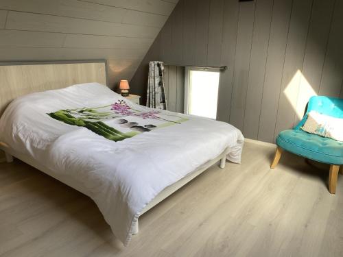 une chambre avec un lit et une chaise bleue dans l'établissement Maison de Charme à Erdeven, Proche Plages et Sentiers, 3 Pièces, 4 Pers, Cour Privée - FR-1-397-38, à Erdeven