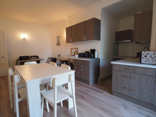 - une cuisine avec une table, des chaises et un comptoir dans l'établissement Appartement en Centre-Ville avec Terrasse et Parking, Accès Direct à la Plage - FR-1-474-4, à Arcachon