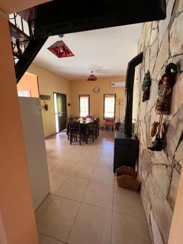 comedor y sala de estar con pared de piedra en Cabañas Samarana en Carpintería