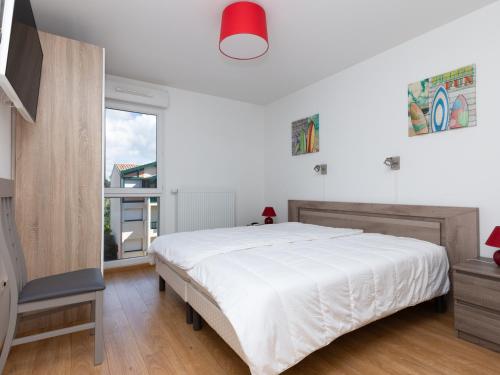 une chambre blanche avec un grand lit et une fenêtre dans l'établissement Superbe appartement neuf à deux pas de la plage avec balcon et parking privé à Capbreton - FR-1-239-387, à Capbreton
