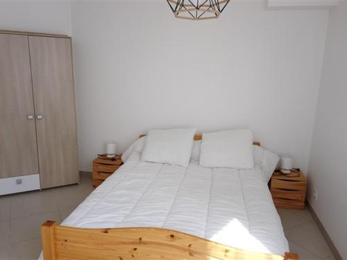 ル・モンドールにあるAppartement Mont-Dore, 3 pièces, 6 personnes - FR-1-415-65のベッドルーム1室(白いシーツと枕が備わる木製ベッド1台付)
