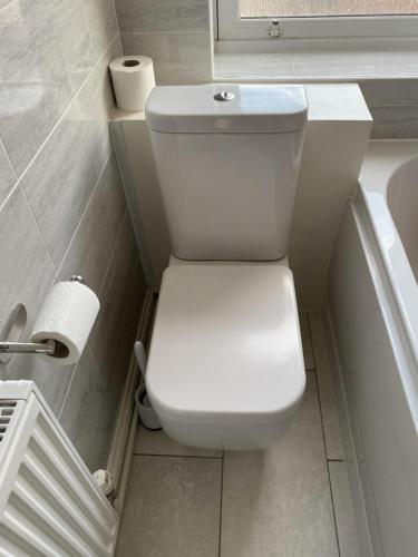 a white toilet in a bathroom next to a tub at Spacious 1 bedroom flat in London in London