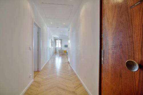 korytarz z drewnianymi drzwiami i białą ścianą w obiekcie REF 909 - Cannes Back Croisette - Apartment for rent w Cannes