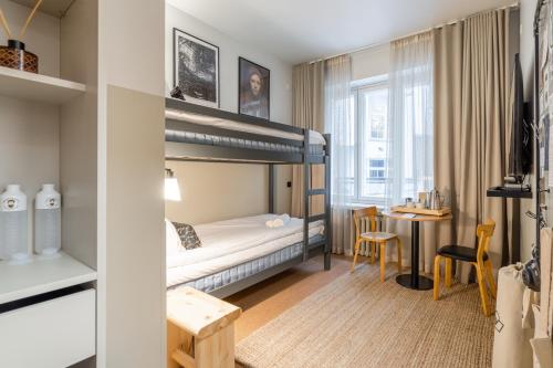 a bedroom with a bunk bed and a desk at Bob W Kluuvi in Helsinki