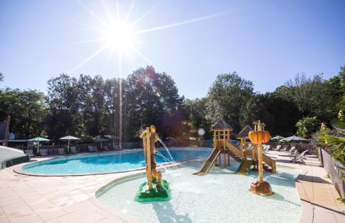 uma piscina com escorregador e playground em Huttopia Beaulieu sur Dordogne em Beaulieu-sur-Dordogne