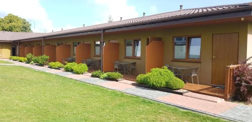 a house with tables and chairs in a yard at Rajska Mierzeja , SAUNA , JAKUZZI ,BASEN Z PODGRZEWANĄ WODĄ , KLIMATYZACJA-OGRZEWANIE , PLAC ZABAW , ROWERY , TARAS in Sarbinowo