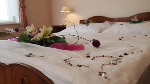 a bed with flowers and a heart made out of buttons at Pension Habermannova Vila in Bludov