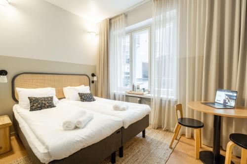 a bedroom with a bed and a table and a window at Bob W Kluuvi in Helsinki