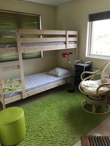 1 dormitorio con 2 literas y alfombra verde en Nösund Holiday Home, en Nösund