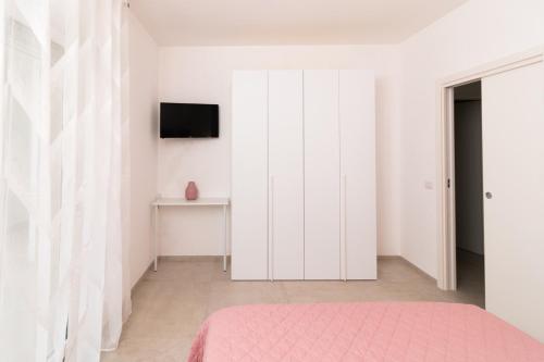 a bedroom with white cabinets and a pink bed at Pietra Fiorita Dimora in Conversano