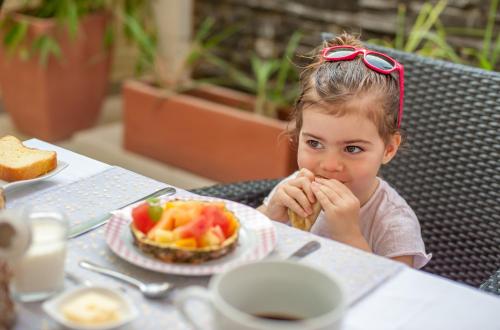 a little girl sitting at a table with a plate of food at La Villa 126 Dakar in Dakar
