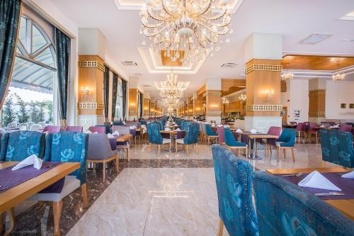 une salle à manger avec des tables et des chaises ainsi qu'un lustre dans l'établissement J'adore Deluxe Hotel & Spa Ultra All Inclusive, à Sidé