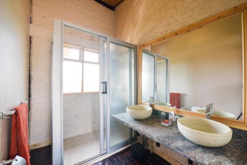 a bathroom with two sinks and a shower at The Coffee Lodge at Clarke Farm in Fort Portal