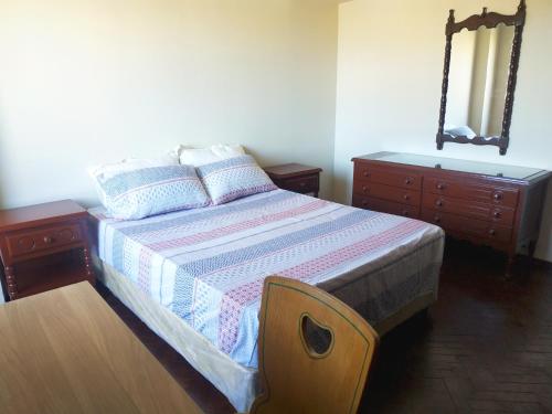 a bedroom with a bed and two dressers and a mirror at Departamento con gran vista en el casco histórico in Asunción