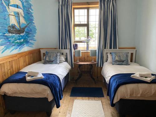 1 dormitorio con 2 camas y un cuadro en la pared en Peerboom Guesthouse, en Fouriesburg
