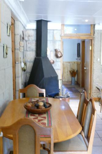 una mesa de madera y sillas con estufa de leña en una habitación en Peerboom Guesthouse, en Fouriesburg