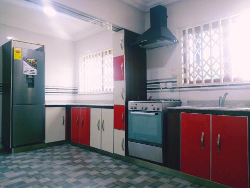 a kitchen with red and white cabinets and a stove at City Stay lodging center in Botianaw