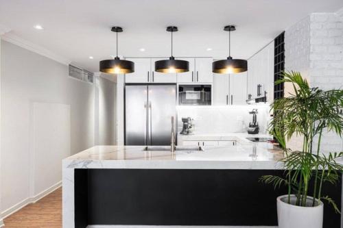 a kitchen with a large white counter with two potted plants at Hermoso departamento en el centro de Milagro in Milagro