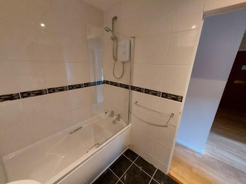 biała łazienka z wanną i prysznicem w obiekcie Granite Getaways - Union Skyview w Aberdeen