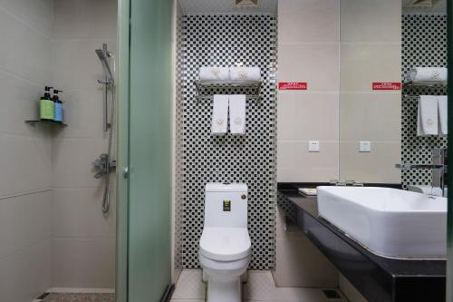 a bathroom with a white toilet and a sink at Jinxinwu Aparthotel Yuancun in Guangzhou