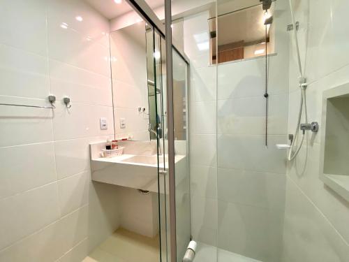 uma casa de banho com um chuveiro e um lavatório. em Residencial SAN MARINO BEIRA MAR em Ilhéus