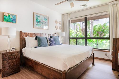 a bedroom with a large bed and a window at Tropical Getaway at the Shores Waikoloa Beach #138 in Waikoloa