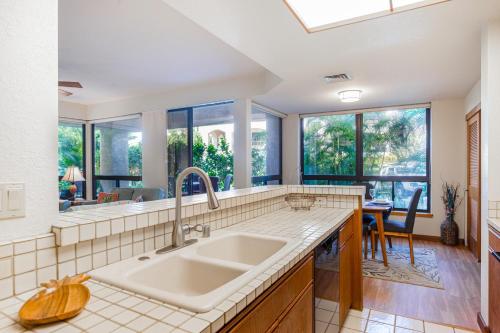 a kitchen with a sink and large windows at Tropical Getaway at the Shores Waikoloa Beach #138 in Waikoloa