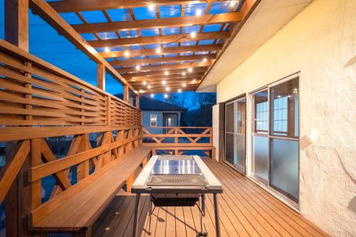 a deck with a bench and a table on it at Bell-Rental Villa Engawa House in Fujikawaguchiko