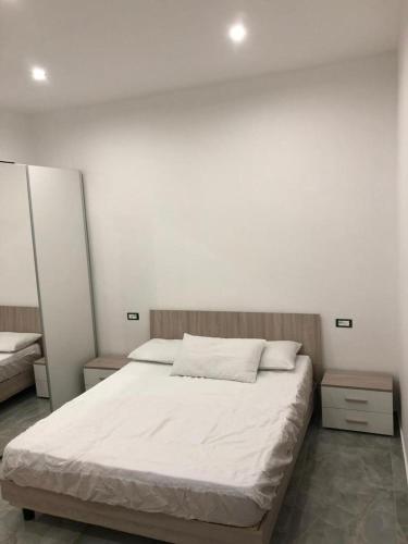 ein Schlafzimmer mit einem großen weißen Bett mit zwei Nachttischen in der Unterkunft 13 Minuti Dal Centro in Reggio di Calabria