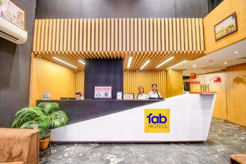 two people sitting at a reception desk in a hotel lobby at FabHotel Prime Kzar Corporate in Kolkata