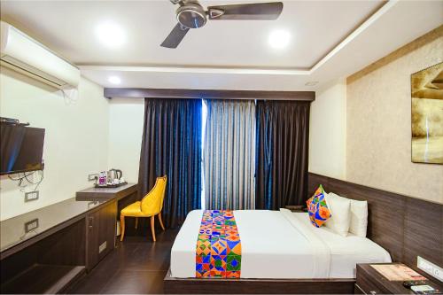 a hotel room with a bed and a desk at FabHotel Prime Kzar Corporate Budget Stay Near Park Street in Kolkata