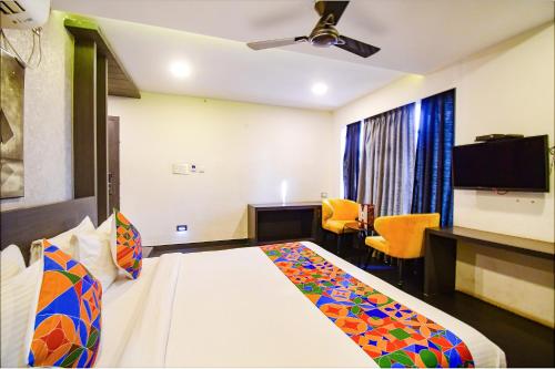 a hotel room with a bed and a tv at FabHotel Prime Kzar Corporate Budget Stay Near Park Street in Kolkata