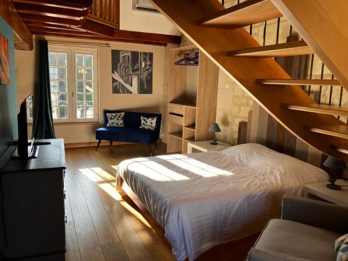 1 dormitorio con 1 cama grande y una escalera en La Bonne Note, en Chinon