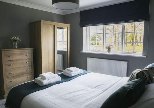 ein Schlafzimmer mit einem Bett mit zwei Handtüchern darauf in der Unterkunft Walshford Lodge in Cowthorpe