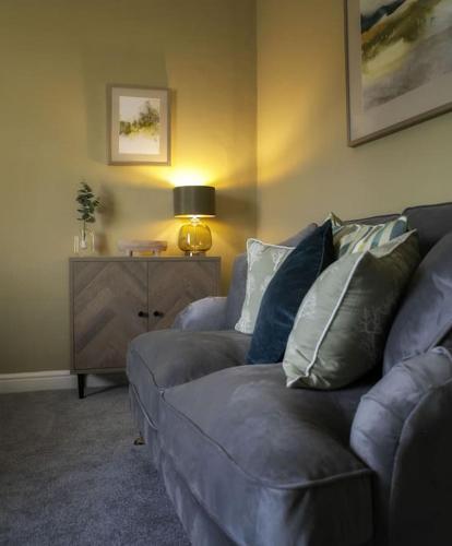 a living room with a couch and a table with a lamp at Walshford Lodge in Cowthorpe