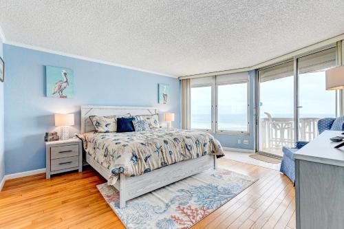 a bedroom with a bed with blue walls and windows at Van Lee 1003 in Ormond Beach