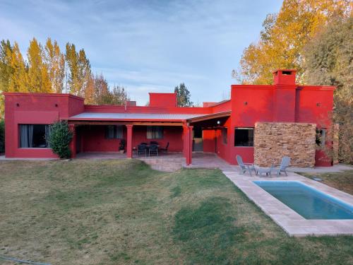 圖努揚的住宿－Puerta 1910，一座红色的房子,前面有一个游泳池