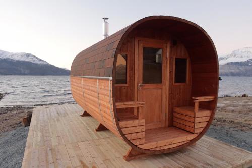 a small wooden hobbit house on the shore of a lake at Solheim Fritidsgård in Svensby