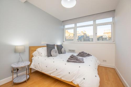 a white bedroom with a bed and a window at Tiramisu House - Luxury 2 Bed Apartment in Aberdeen Centre in Aberdeen