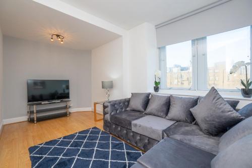 uma sala de estar com um sofá e uma televisão de ecrã plano em Tiramisu House - Luxury 2 Bed Apartment in Aberdeen Centre em Aberdeen