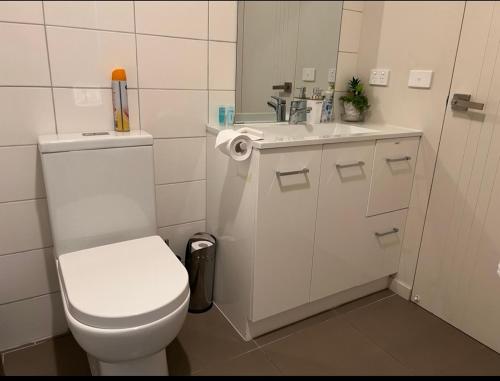 a white bathroom with a toilet and a sink at Lake Esmond Place in Canadian