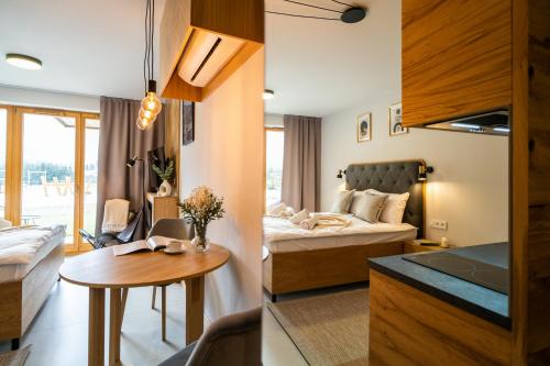 a bedroom and a living room with a bed and a table at Apartament Wielka Turnia by Apart Concept Podhale in Kościelisko