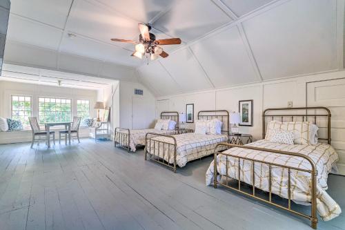 a room with four beds and a ceiling fan at The Darcy in Hot Springs