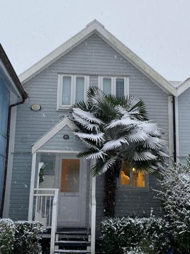 a house with a palm tree in front of it at Herons Hideout in South Cerney