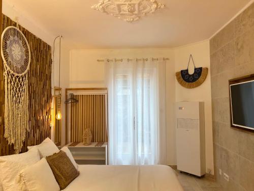 une chambre avec un lit blanc et une télévision dans l'établissement My Pad Provence, à Avignon
