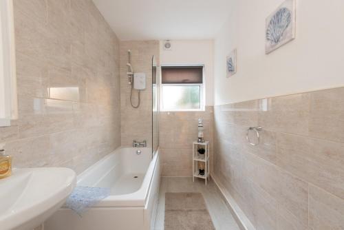 a bathroom with a bath tub and a sink at Pease Street in Darlington