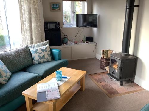 a living room with a couch and a wood stove at Villa Farm Cottage in Thornton Curtis