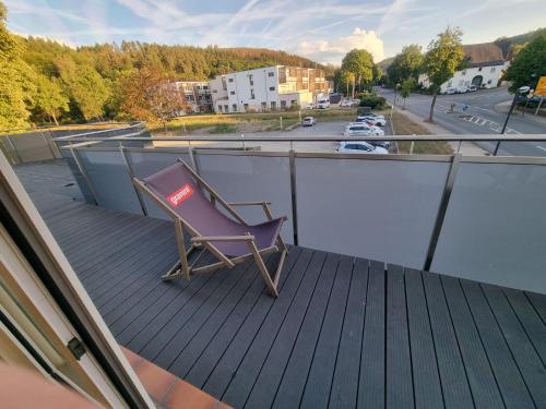 a chair sitting on the deck of a balcony at Lübkes Ferienwohnungen & Apartments in Allendorf